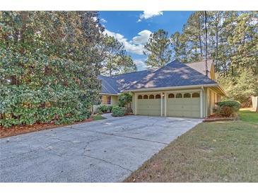 Charming home with a two-car garage, mature trees, and a long driveway at 1559 Norwood Dr, Lilburn, GA 30047