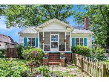 Charming home with a cozy screened front porch, brick steps, lush landscaping, and bright blue shutters at 212 South Se Ave, Marietta, GA 30060