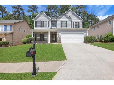 Charming two-story home with a well-manicured lawn and a two-car garage at 3208 Juniper Nw Dr, Kennesaw, GA 30144
