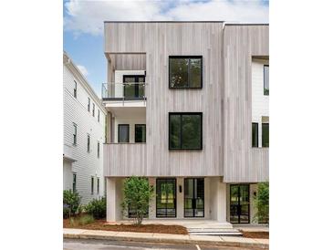 Modern, three-story home with light wood siding, black-framed windows, and a small balcony at 11542 Serenbe Ln, Chattahoochee Hills, GA 30268