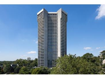 High-rise building with balconies in a residential area surrounded by lush greenery against a blue sky at 2660 Peachtree Rd # 7F, Atlanta, GA 30305