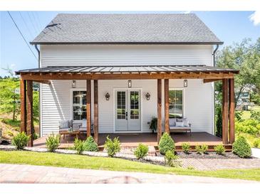 Charming home with a welcoming front porch featuring wooden columns and comfortable seating at 50 Maple St, Roswell, GA 30075