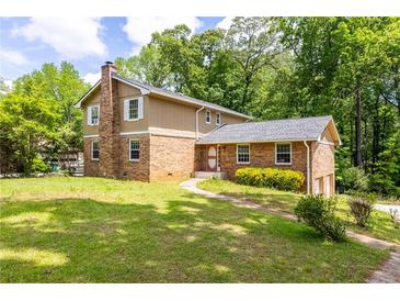 Charming brick home with a well-maintained lawn and mature trees at 440 Ohern Ct, Stone Mountain, GA 30088