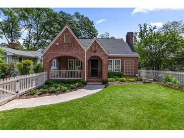Charming brick Tudor home features a covered porch and a lush, well-manicured front lawn at 97 Peachtree Hills Ne Ave, Atlanta, GA 30305