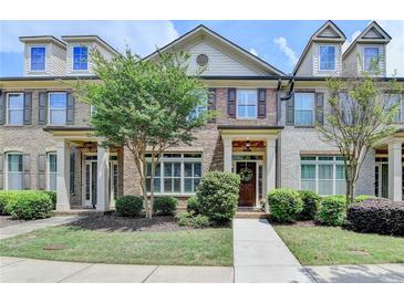 Charming townhome featuring brick and siding accents, complemented by mature landscaping and inviting entryway at 7725 Pierpoint Ln, Alpharetta, GA 30005