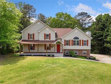 Charming two-story home with a welcoming front porch and lush green lawn at 405 Maple Rdg, White, GA 30184