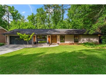 Charming ranch-style home boasts a lush green lawn, modern windows, and an attached two-car garage at 1749 Ridge Valley Nw Ct, Atlanta, GA 30327