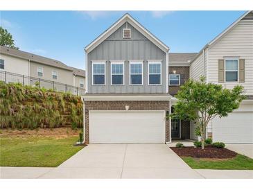 Charming two-story townhome with a two-car garage and professionally landscaped front yard at 302 Braswell Ct, Woodstock, GA 30188