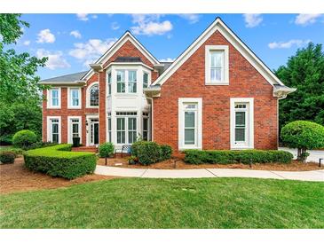 Charming red brick home featuring manicured landscaping and a beautiful bay window at 3052 Fleet Sw St, Marietta, GA 30064