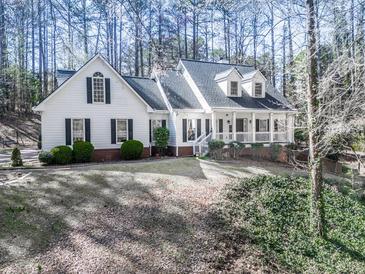 Charming home with a welcoming front porch, manicured lawn, and mature trees at 5090 Eubanks Rd, Woodstock, GA 30188