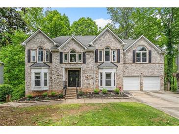 Charming two-story brick home with a landscaped front yard and two-car garage at 4365 Dover Crossing Dr, Marietta, GA 30066
