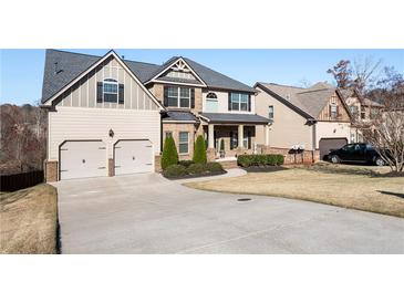 Charming two-story home with a manicured lawn, a long driveway, and a two-car garage at 6280 Stillwood Ln, Cumming, GA 30041