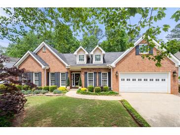 Charming brick home with a well-manicured lawn, black shutters, and attached two-car garage at 3151 Amesbury Way, Duluth, GA 30096