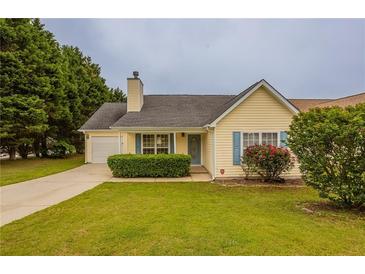 Charming yellow home with blue shutters, green lawn and mature trees at 4045 Meadow Glen Way, Fairburn, GA 30213