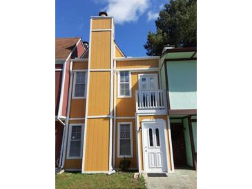 Charming townhome featuring a yellow exterior, white trim, and a small balcony, offering a cozy curb appeal at 3820 London Dr Dr, Decatur, GA 30032