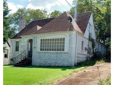 Charming brick home featuring a traditional roof, well-manicured lawn, and inviting front entrance at 1624 Beecher Sw St, Atlanta, GA 30310