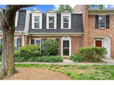 Charming brick townhome with well-maintained landscaping, black shutters, and a welcoming entrance at 5 Newport Nw Pl, Atlanta, GA 30318