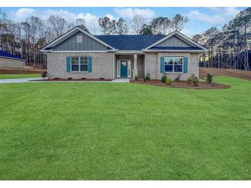 Charming brick home with a well-manicured lawn, complemented by dark blue shutters and a matching door at 5291 Tuscany Dr, Douglasville, GA 30135