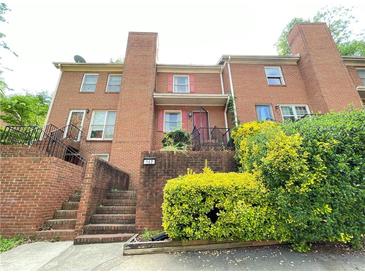 Brick condo building featuring multiple stories, a well-maintained entrance, and lush surrounding greenery at 142 Davis Mill Ct, Lawrenceville, GA 30044