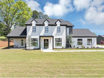 Stunning two-story home with a modern design, complemented by a lush green lawn and mature trees at 2577 Kilgore Rd, Buford, GA 30519