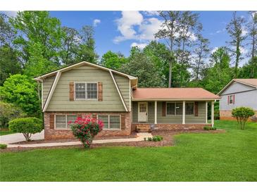 Charming home featuring mature trees, a well-maintained lawn and an inviting exterior at 3240 Corktree Trl, Stonecrest, GA 30038