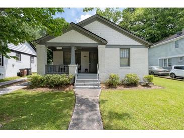 Charming brick home with a well-manicured lawn and inviting front porch at 2284 Dauphine St, East Point, GA 30344