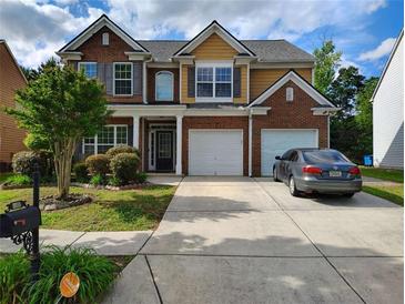Charming two-story home with brick and siding exterior, landscaped front yard, and a two-car garage at 1117 Balvaird Dr, Lawrenceville, GA 30045