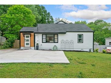 Charming home featuring a well-maintained lawn and a concrete driveway at 428 Tibbetts Se St, Marietta, GA 30060