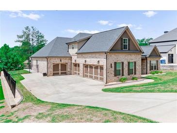 A brick home featuring a three-car garage and an expansive driveway at 953 Auburn Rd, Dacula, GA 30019