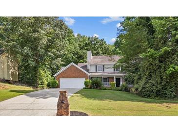 Charming two-story home with brick accents, a well-manicured lawn, and a spacious two car garage at 4524 Shumart Dr, Snellville, GA 30039