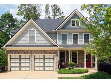 Charming two-story home with a two-car garage, stone accents, and well-maintained landscaping and a red front door at 93 Richmond Way, Villa Rica, GA 30180