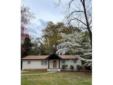 Charming single story home with white brick and mature landscaping at 3133 Rebecca St, Covington, GA 30014