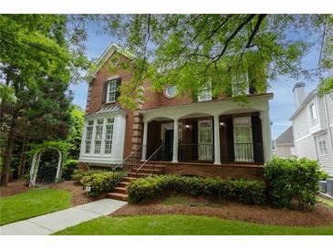 Charming two-story brick home with a welcoming front porch and beautifully landscaped front yard at 2174 Basque Se Dr, Smyrna, GA 30080
