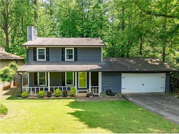 Charming two-story home with a welcoming front porch and well-manicured lawn provides great curb appeal at 555 Creekwood Xing, Roswell, GA 30076