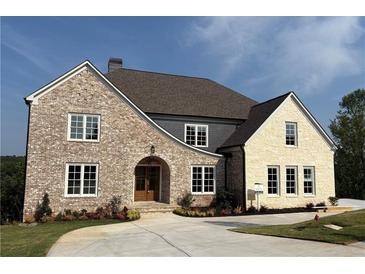 Stunning new construction home with brick and stone accents, complemented by a meticulously landscaped front yard at 5753 Brendlynn Dr, Suwanee, GA 30024