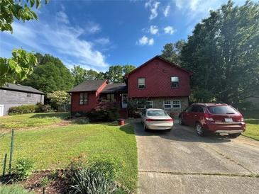 Charming red two-story home featuring a stone facade, a well-maintained lawn, and a private driveway at 2539 Dogwood Hills Ct, Austell, GA 30106