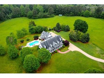 Expansive aerial view of estate home with inviting pool, surrounded by lush landscaping and mature trees at 1415 N Flat Rock Rd, Douglasville, GA 30134