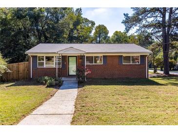 Charming single-story brick home featuring a well-manicured front lawn and inviting curb appeal at 1661 Barrett Nw Dr, Atlanta, GA 30318