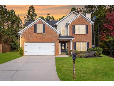 Beautiful two-story brick home with a well-manicured lawn and two car garage at 5885 Raventree Ct, South Fulton, GA 30349