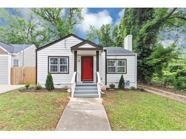 Charming bungalow with a red front door, landscaped yard and a welcoming entrance at 942 Lawton Sw St, Atlanta, GA 30310