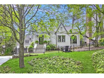 Charming home with a manicured lawn, iron fence and beautiful landscaping at 820 Wilson Nw Rd, Atlanta, GA 30318