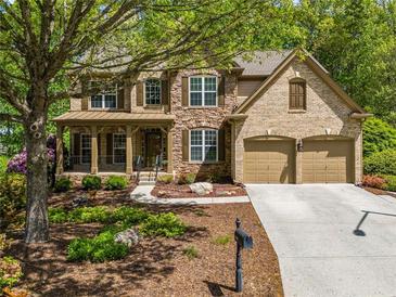 Charming two-story home boasts a stone and brick facade, two car garage and a beautifully landscaped front yard at 121 Brendylynn Trce, Woodstock, GA 30188