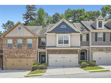 Charming townhome with stone accents, neutral siding, and attached two-car garage nestled in a well-manicured community at 2212 Knoxhill Se Vw, Smyrna, GA 30082