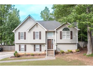 Charming two-story home with light siding, inviting front porch, and neatly landscaped yard at 324 Madeline Way, Temple, GA 30179