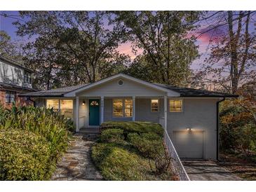 Charming brick home with a well-manicured lawn, inviting entrance, and attached garage at 490 E Pharr Rd, Decatur, GA 30030