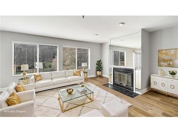 Bright living room with modern decor, fireplace, and large windows allowing ample natural light at 27 Lakes Edge Se Dr, Smyrna, GA 30080