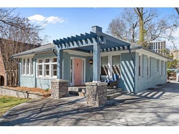 Charming blue home featuring a unique pergola over the front porch and a pink front door at 28 Peachtree Hills Ne Ave, Atlanta, GA 30305