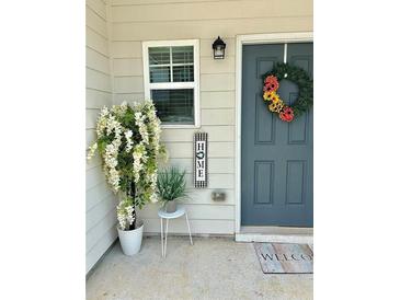 Charming home entrance with a decorative wreath, plants, and a 