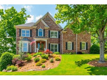 Beautiful two-story brick home boasts lush landscaping, an inviting entrance, and a well-manicured lawn at 7048 Bennington Ln, Cumming, GA 30041