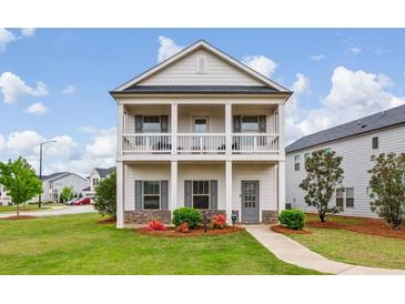 Charming two-story home featuring a welcoming front porch, manicured lawn, and beautiful landscaping at 4724 Electric Sw Ave, Mableton, GA 30126